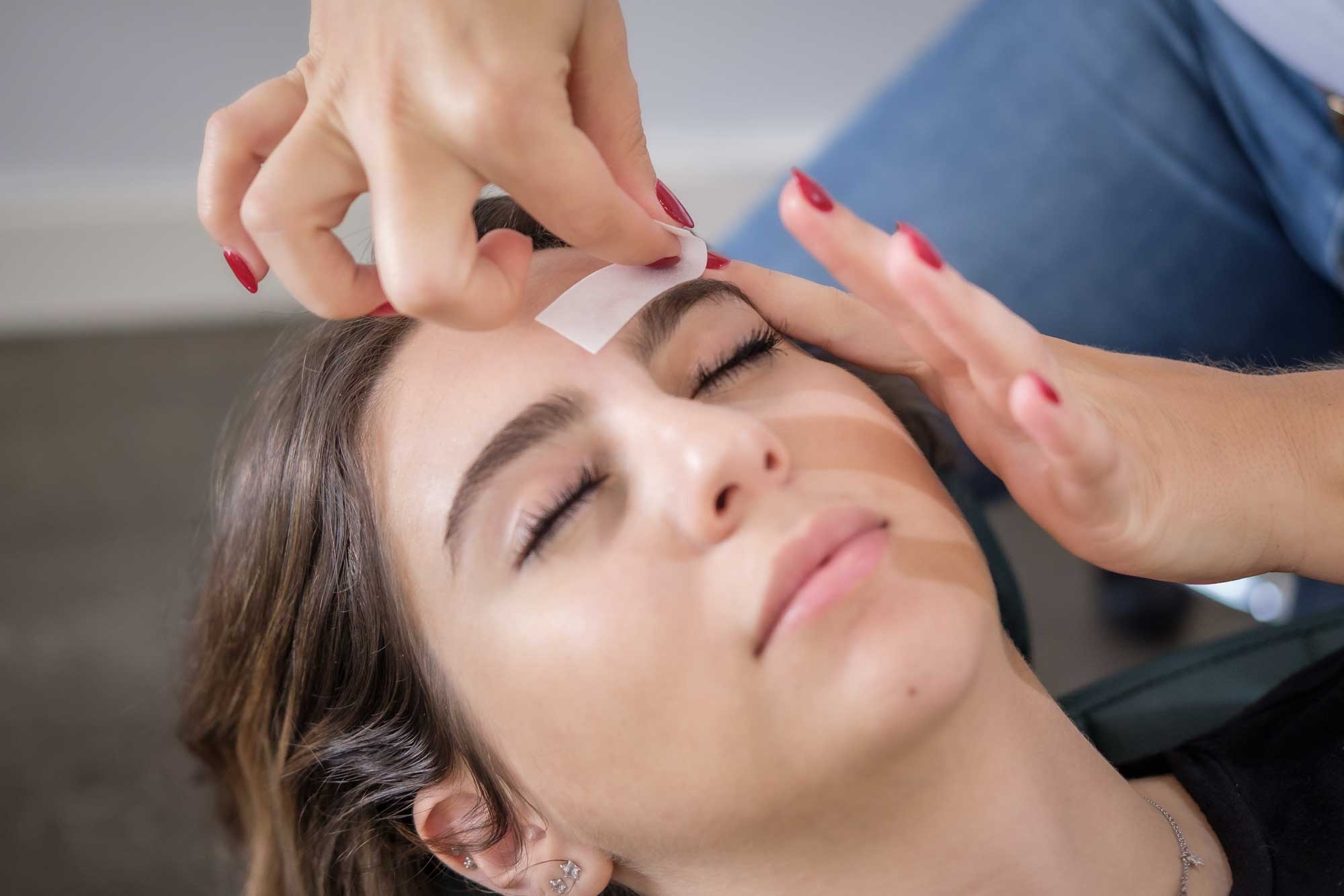 A women getting her eyebrows waxed at the salon